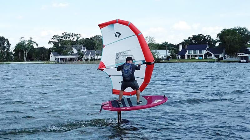 Wing foiler gliding above Lake Fairview on a hydrofoil